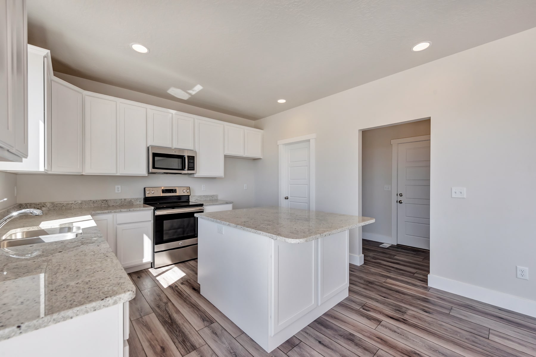 Kitchen with an island in a new home from McArthur Homes.