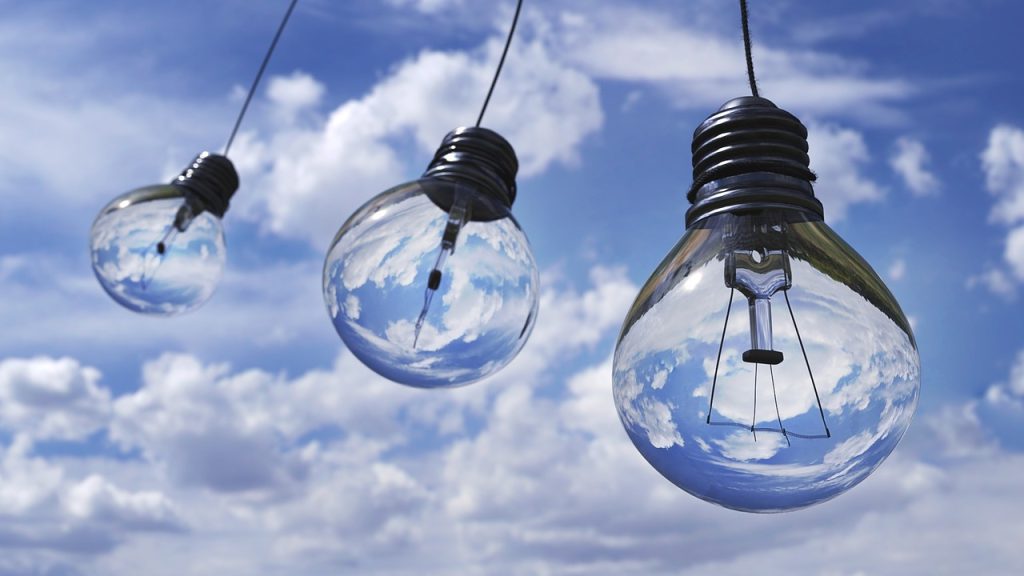3 lightbulbs against a cloudy sky
