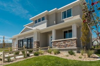  A gray two-story home with a wooden fence