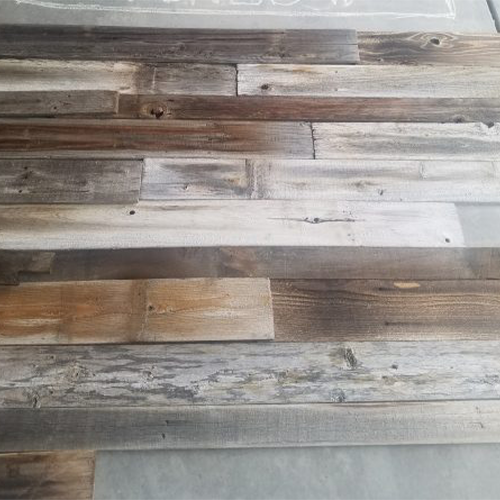 Close-up view of a reclaimed wood surface made from various planks in mixed shades of brown, gray, and whitewash