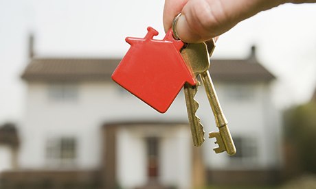 Keys with red house keychain in front of new home construction in Utah