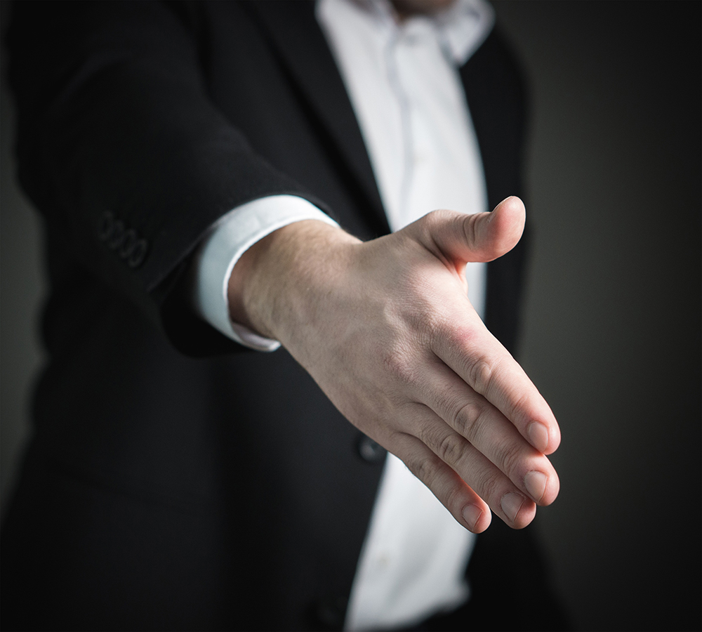 A man reaches out his hand for a handshake