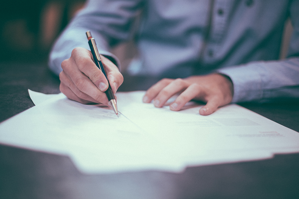 A man signing a contract to buy a home