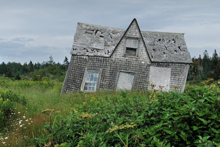House Leaning To The Side In a Field