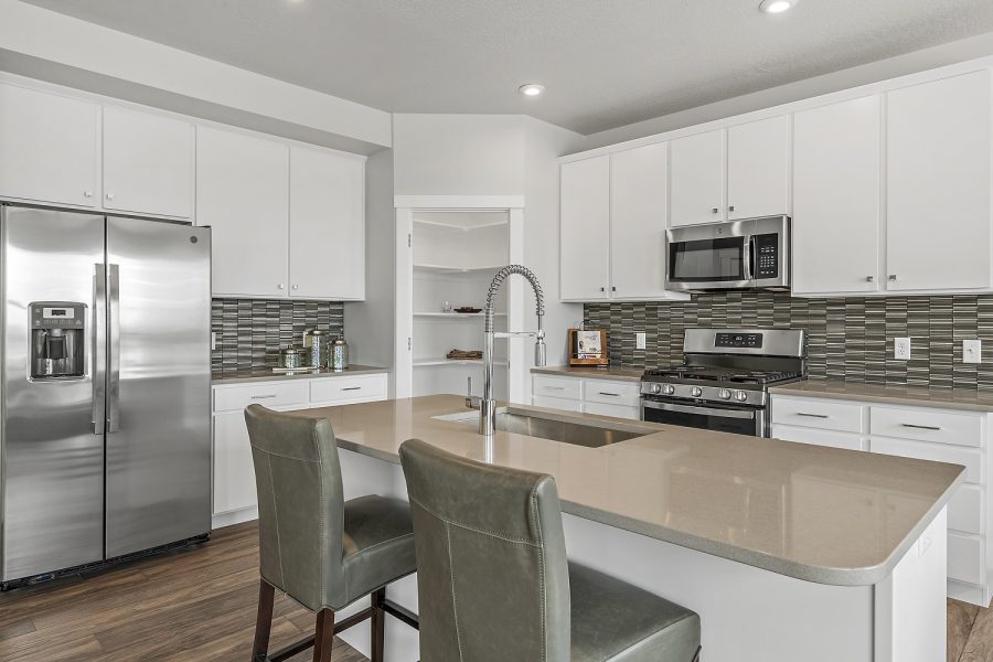 New home full kitchen view with island that has a sink
