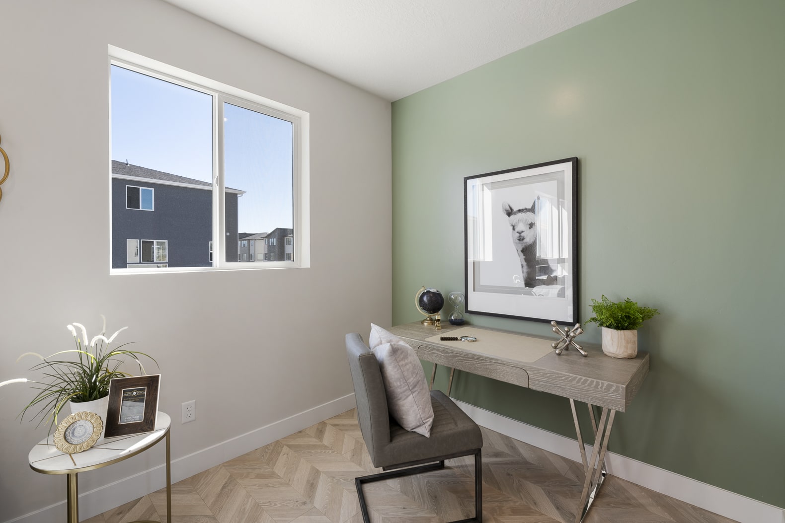 Home office option with a green wall and lama photo on the wall.