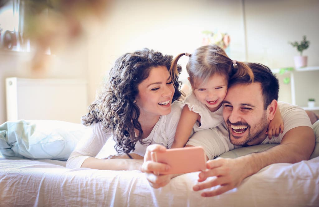 Family At Home Looking At Phone Laughing
