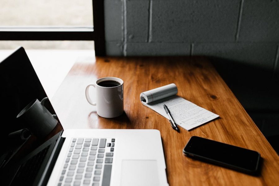 Laptop, A Phone, A Cup of Coffee, A Notepad and Pen In A New Home From McArthur Homes