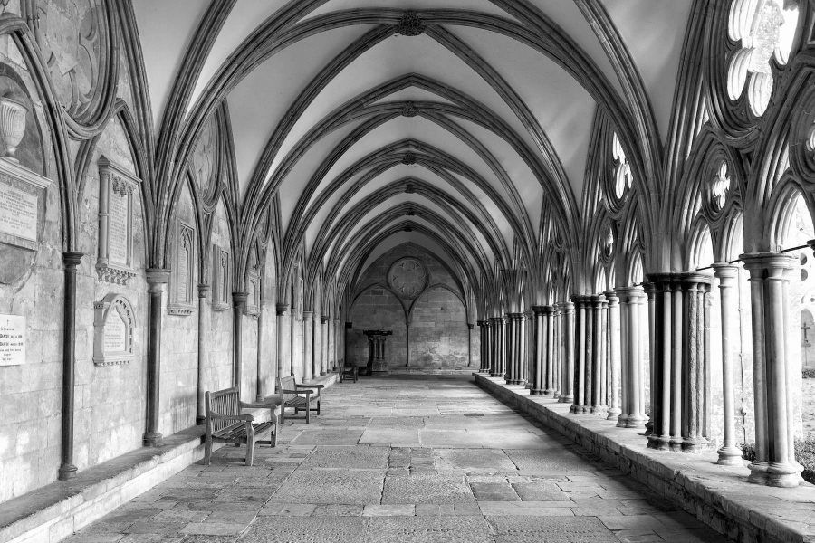 black and white image of the external covered walkway of the salisbury cathedral cloisters. an exterior walkway around the outside of the cathedral.