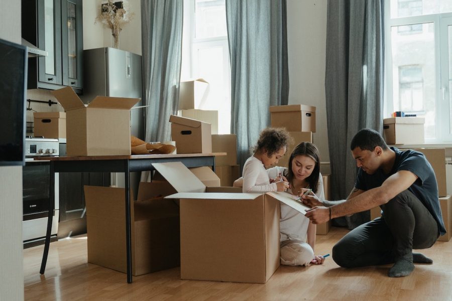 Family Packing Boxes With Child to Move to New McArthur Home