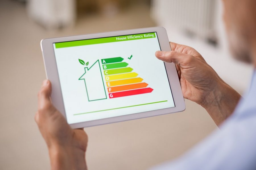 Person Holding Tablet Looking Over Energy Efficient Report for New Home