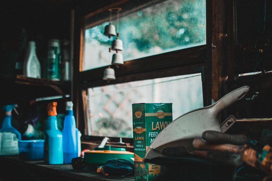 Green Lawn Box Beside Bottles and Window In Garage