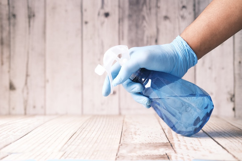 Spraying Cleaner on Laminate Floor