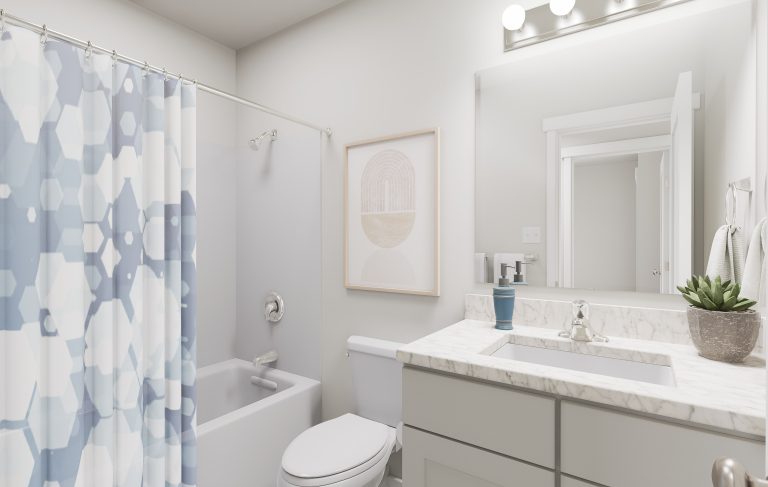 Modern bathroom in homes in Utah featuring a white bathtub and blue geometric shower curtain, white toilet, light gray vanity with marble countertop, round sink, mirror, potted plant, and neutral wall art. Bright overhead lighting.