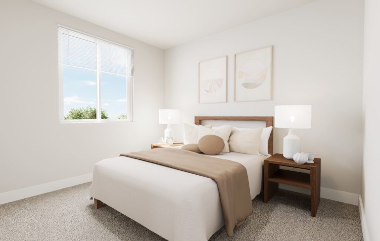 A bright, minimalist bedroom found in many homes in Utah, featuring a neatly made bed with a beige blanket, neutral pillows, two wooden nightstands with white lamps, abstract art above the bed, and a large window letting in natural light.