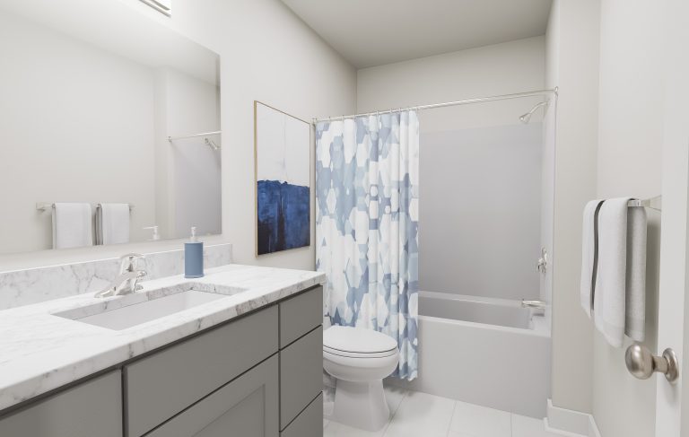 Modern bathroom with a gray vanity, marble countertop, sink, toilet, and bathtub. A blue and white geometric shower curtain and abstract wall art add color—stylish touches often found in homes in Utah. White towels are hanging on the wall.
