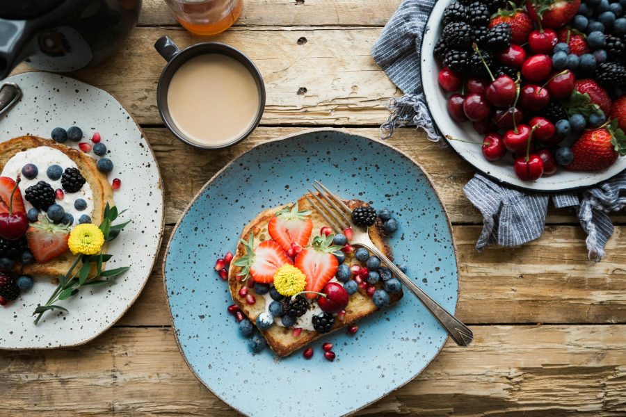 A beautifully plated dish with vibrant ingredients, accompanied by side dishes and garnishes, presented on a rustic table setting.