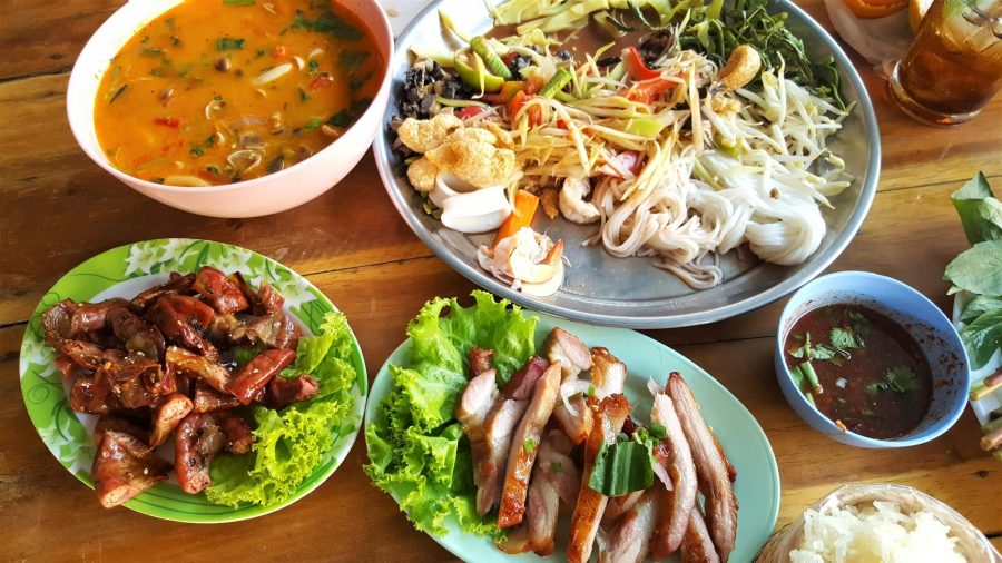 A spread of assorted dishes, including salads, sauces, and grilled items, showcasing a variety of colorful and flavorful foods.