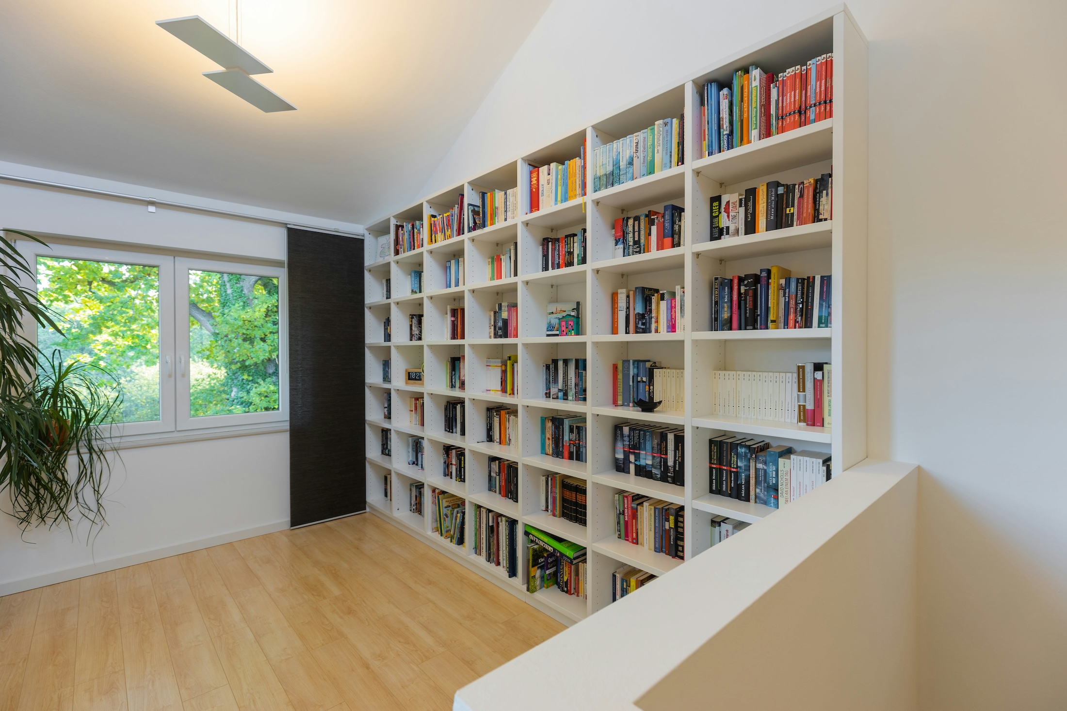 A loft area with a book shelf filled with books in a new home