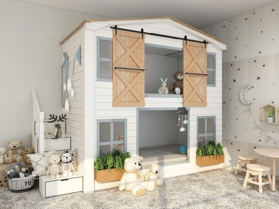 Charming children's bedroom featuring a white two-level playhouse-style bunk bed with barn-style sliding doors, soft toys, built-in stairs, and star-patterned wall decor.