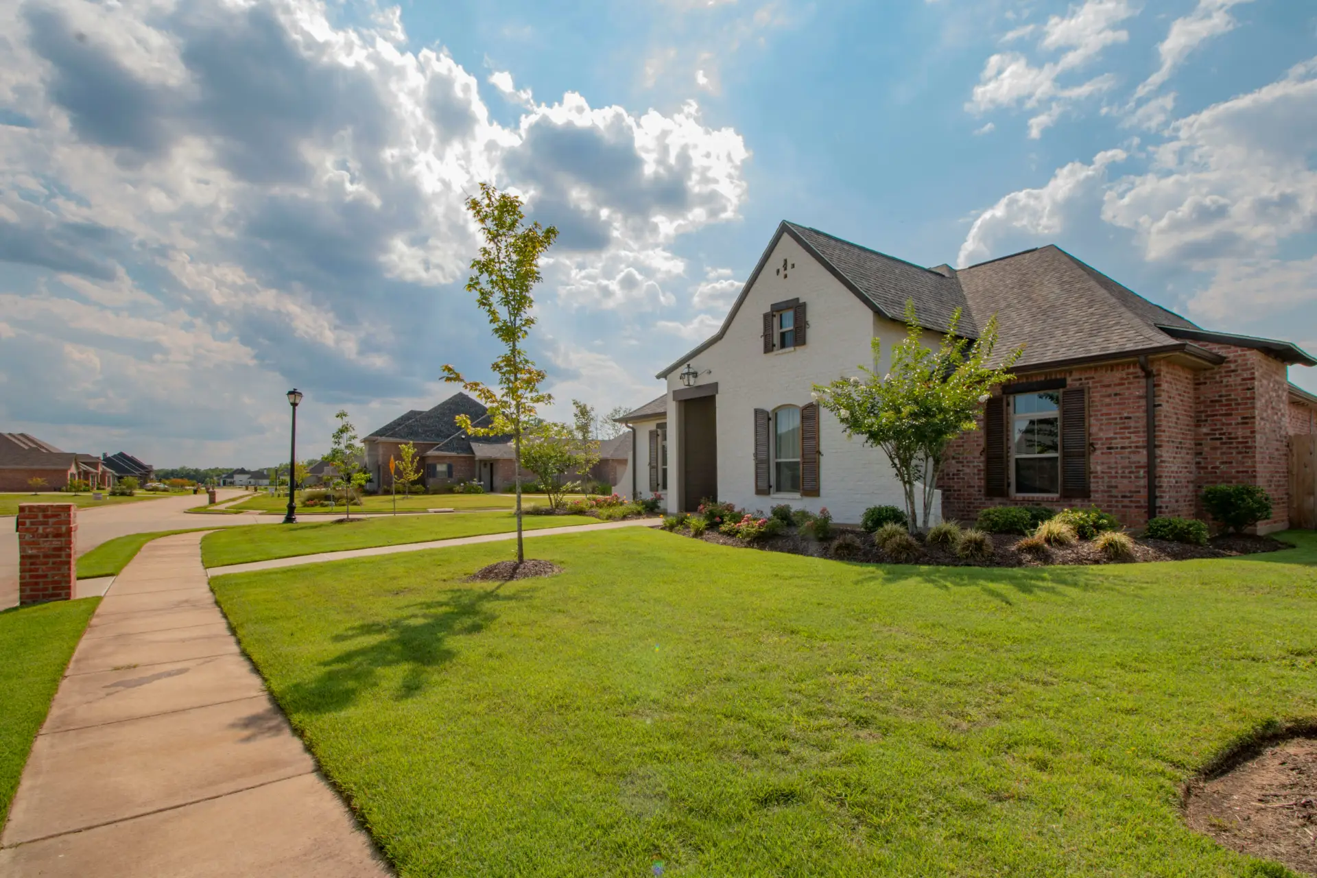 Street view of a McArthur Homes community featuring new single-family homes and townhomes in Utah.