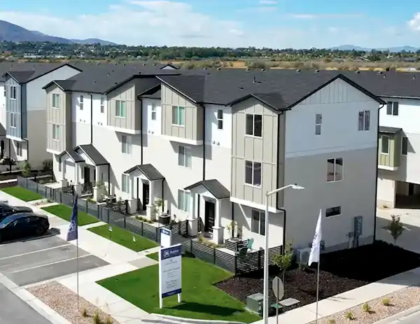 Row of three-story townhomes at Arrowhead with white and gray siding, private entries, and fenced yards