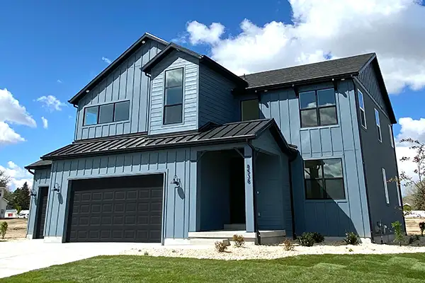Two-story blue home at Pagoda Grove with board-and-batten siding and a dark two-car garage