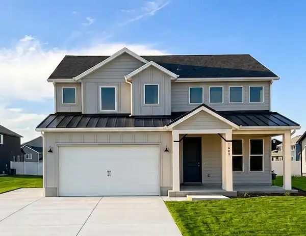 Two-story home at Stagecoach Estates with greige siding, white two-car garage, and covered front porch